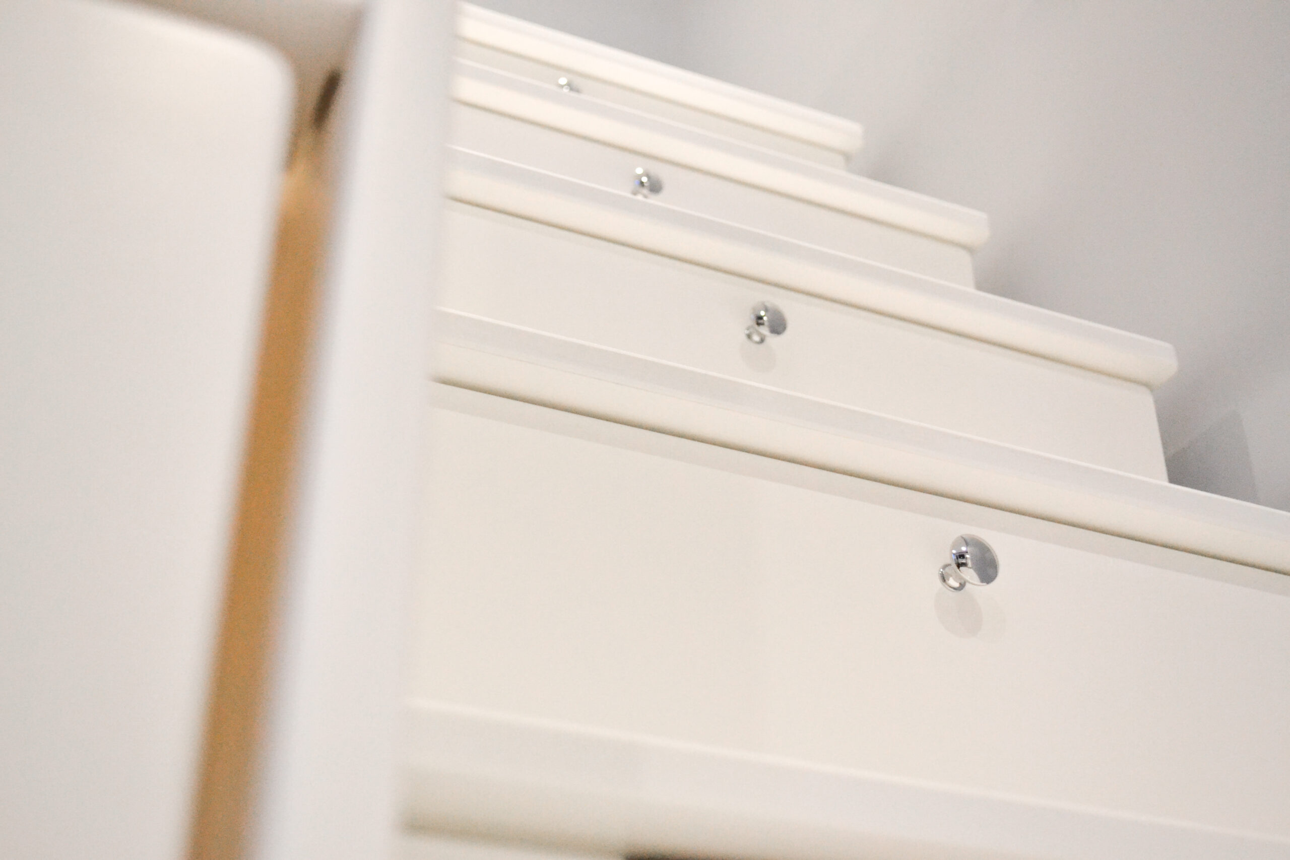 beautiful white storage drawers in a stair case on a birch multiply bunk bed finished in an eco friendly varnish
