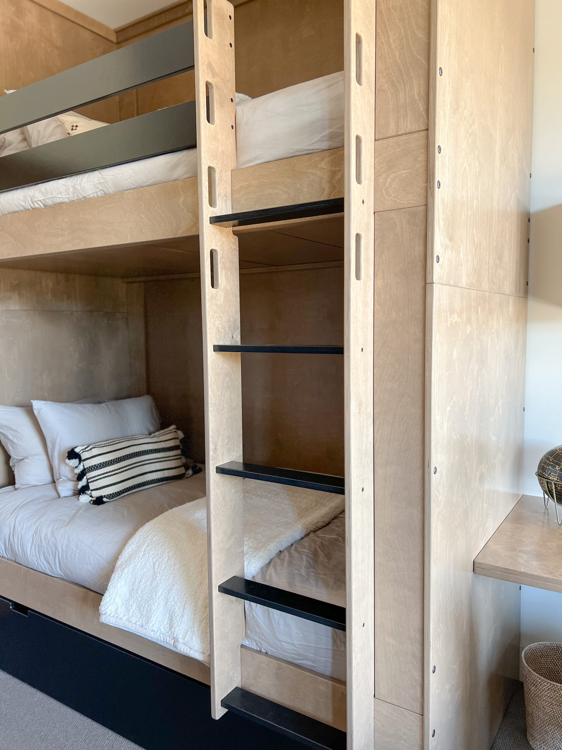 a beautiful bunk room design all custom made to fit this room made out of birch multiply finished in a warm driftwood stain with black accents.